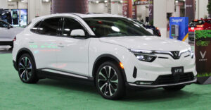 Белый VinFast VF8 припаркован на современной городской набережной